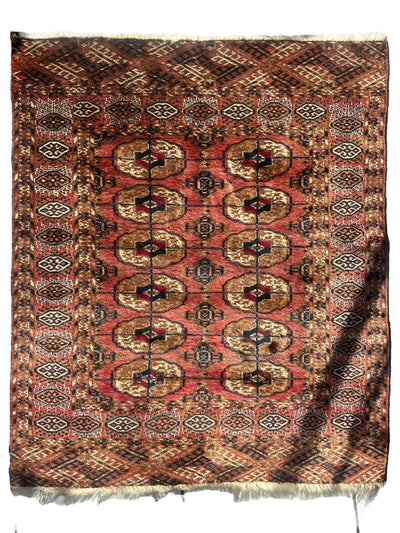 Vintage Tribal Turkoman Tekke Rug spread out displaying intricate tribal patterns in natural light