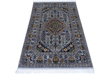 Hand-knotted Afghani Zerkhaki wool rug featuring a central medallion and intricate floral and geometric patterns in muted blue, gold, black, and green tones with fringed edges.