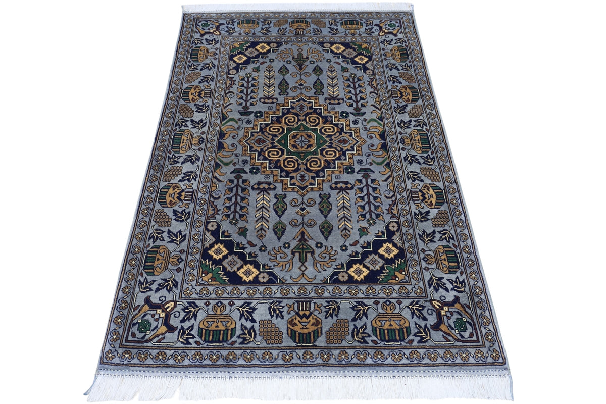 Hand-knotted Afghani Zerkhaki wool rug featuring a central medallion and intricate floral and geometric patterns in muted blue, gold, black, and green tones with fringed edges.