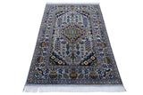 Rectangular hand-knotted Afghani Zerkhaki wool rug with a central medallion in navy, green, and mustard on a pale blue background, featuring floral and geometric patterns and white fringes.