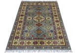 Hand-knotted Afghani Kazak wool rug with muted blue center, intricate multicolor geometric patterns, and cream border with floral motifs and fringed ends.