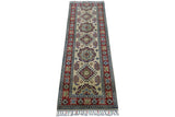 Long narrow hand-knotted Afghani Kazak wool rug with ivory center featuring geometric medallions and a red border decorated with stylized floral motifs and fringed ends.