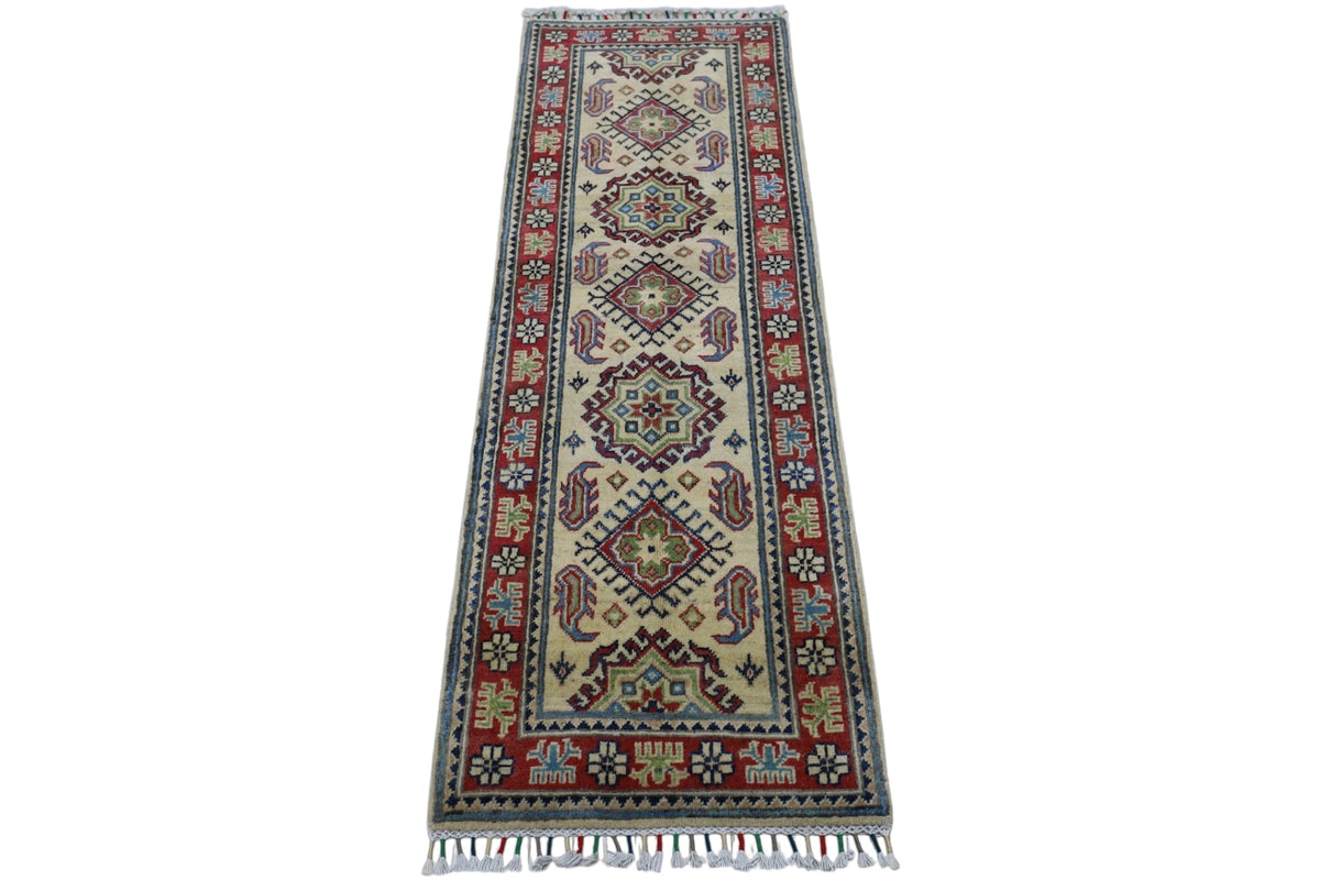 Long narrow hand-knotted Afghani Kazak wool rug with ivory center featuring geometric medallions and a red border decorated with stylized floral motifs and fringed ends.