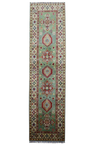Hand-knotted Afghani Kazak wool rug featuring pistachio and red, sized 2’9″ x 9’2″, laid on floor
