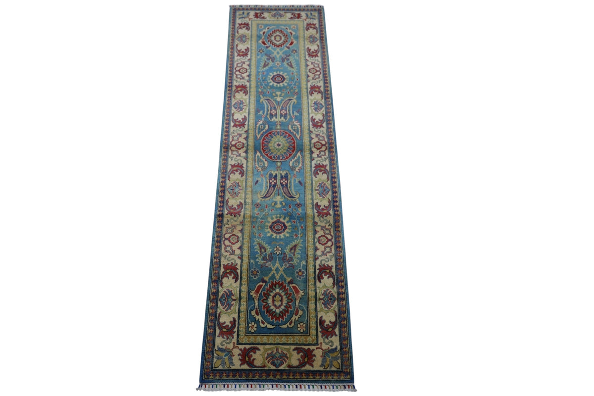 Long narrow hand-knotted Afghani Kazak wool rug with light blue center panel featuring red, cream, and dark blue geometric medallions and a cream border with floral patterns.
