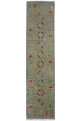 Hand-knotted Afghani Kazak wool runner rug in pistachio color, displayed on wood flooring