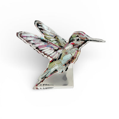 Hummingbird Acrylic Tabletop Art displayed on a wooden desk with a vintage book and green plant