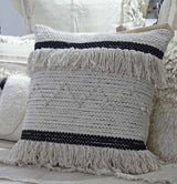 Square throw pillow cover with black and beige horizontal stripes, tasseled edges, and textured woven pattern on a light fabric background.