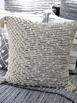 Beige woven throw pillow cover with insert, styled on a wooden slatted surface