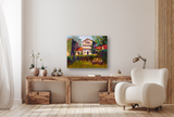 Painting of a house with red roofs and lush greenery hanging above a natural wood console table, next to a modern white armchair and brass floor lamp.