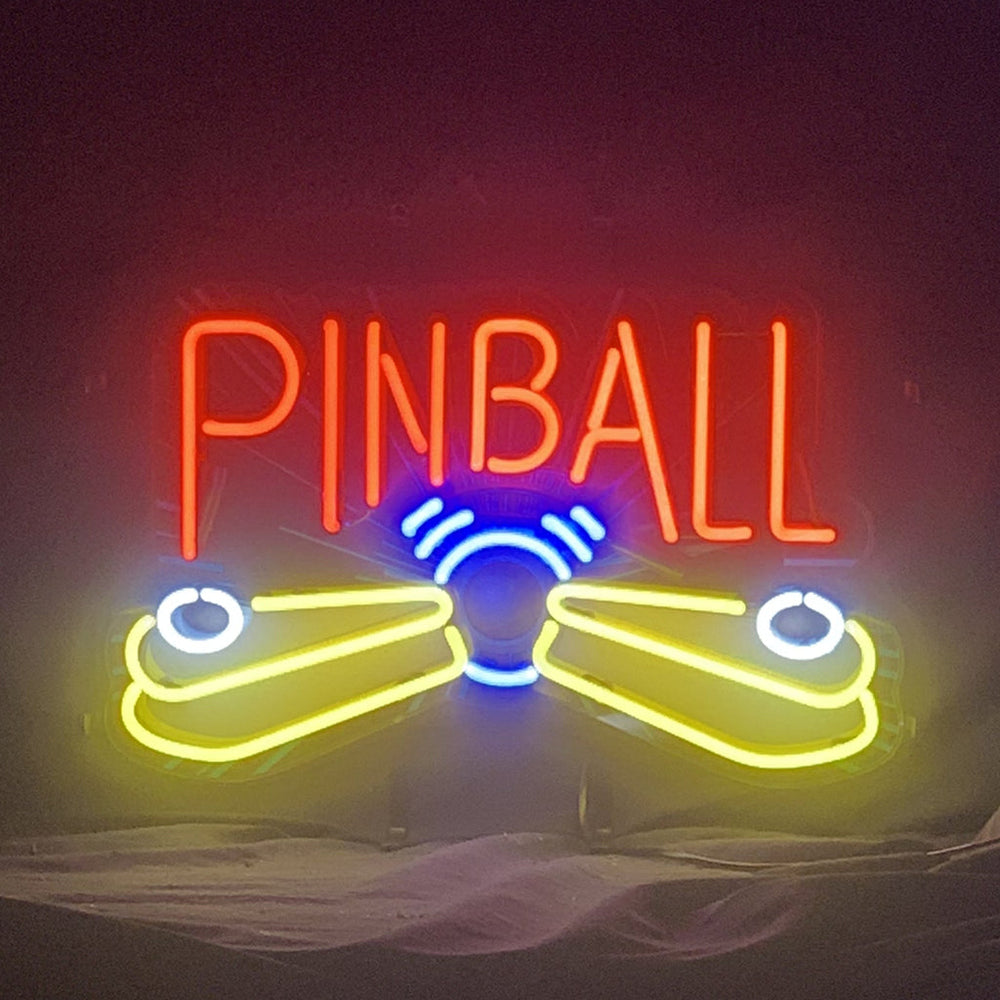 Pinball Game Machine Neon Sign lit against a dark background, showing vibrant neon colors and metal grid backing