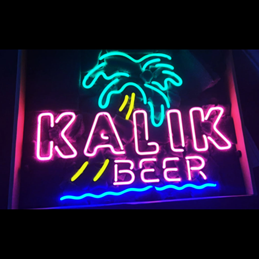 Neon sign with teal palm tree and pink letters spelling 'KALIK' above yellow accents and pink 'BEER' with blue wave line below on dark background