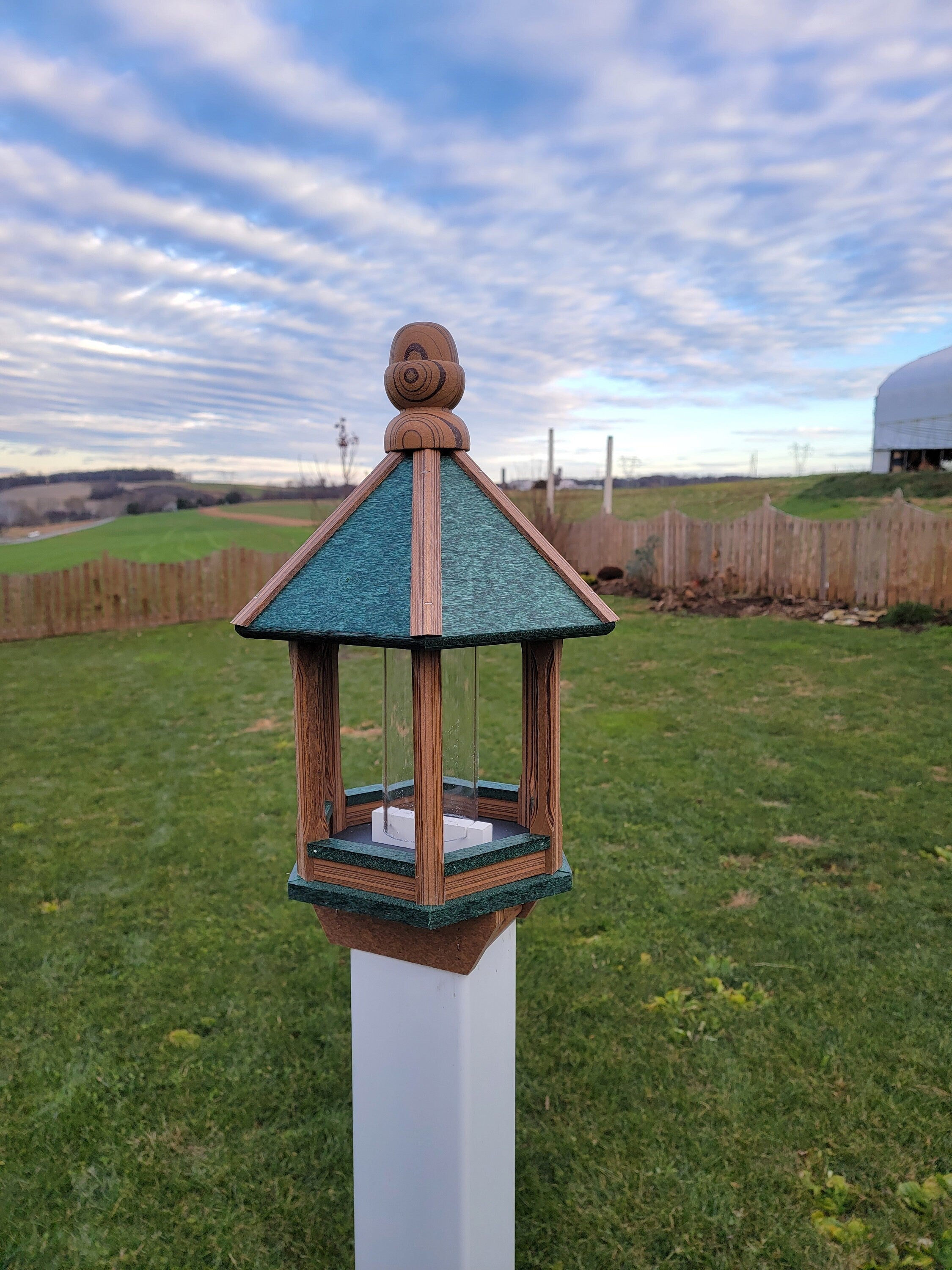 Amish handmade poly bird feeder with rustic spindle design, shown mounted outdoors