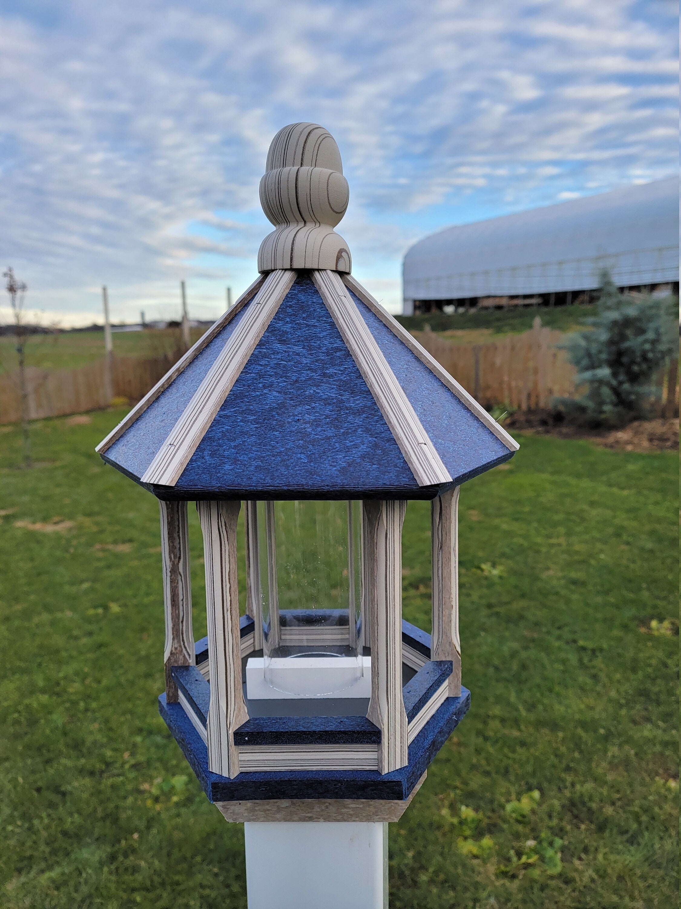 Amish handmade poly bird feeder with rustic spindle design, shown mounted outdoors
