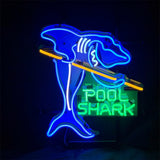Neon sign depicting a blue shark holding a yellow pool cue with green text reading 'POOL SHARK' beneath it on a black background.