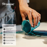 Hand pouring turquoise epoxy resin from a cup onto a flat surface with printed instructions on how to use Promise Epoxy beside it.