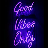 Purple glowing Good Vibes Only neon sign mounted on wall