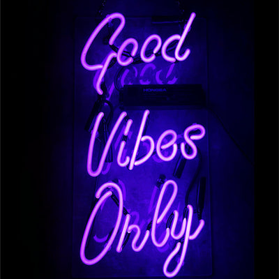 Purple glowing Good Vibes Only neon sign mounted on wall
