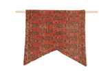 Limited edition RUGLING 01 wall hanging showing antique Mir Serbend Persian rug fragment mounted on a cork board with wooden dowels for hanging.