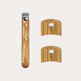 Three wood knife handles with natural grain and metal fittings, including one long with two rivets and two shorter curved pieces with central holes and logo.