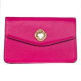 Vibrant fuchsia leather clutch with a geometric gold-tone frame featuring a large clear Swarovski stone at the center of the envelope flap closure.