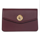 Bordeaux leather clutch with a rectangular flap and a central gold-toned hexagonal Swarovski stone accent on a white background