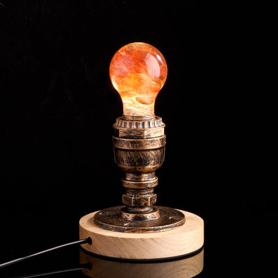 Handcrafted sunflower-shaped resin LED light bulb glowing warmly on a dark background