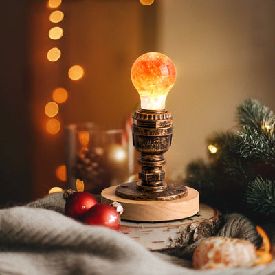 Handcrafted sunflower-shaped resin LED light bulb glowing warmly on a dark background