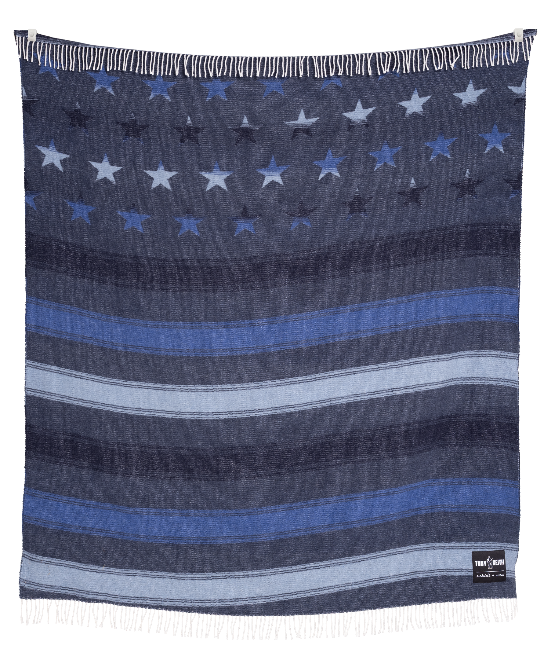 Toby Keith Frontier blanket folded and draped over a wooden chair showcasing a beige and neutral color palette