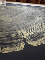 Close-up of an original artwork showing gold tree rings on a black background, inspired by redwood wood patterns, signed and measuring 36x48 inches.
