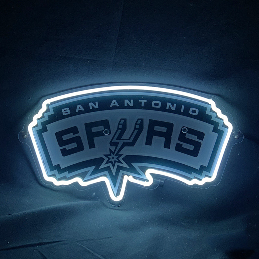 White neon light outlining San Antonio Spurs basketball logo with stylized spur emblem, mounted on dark background.
