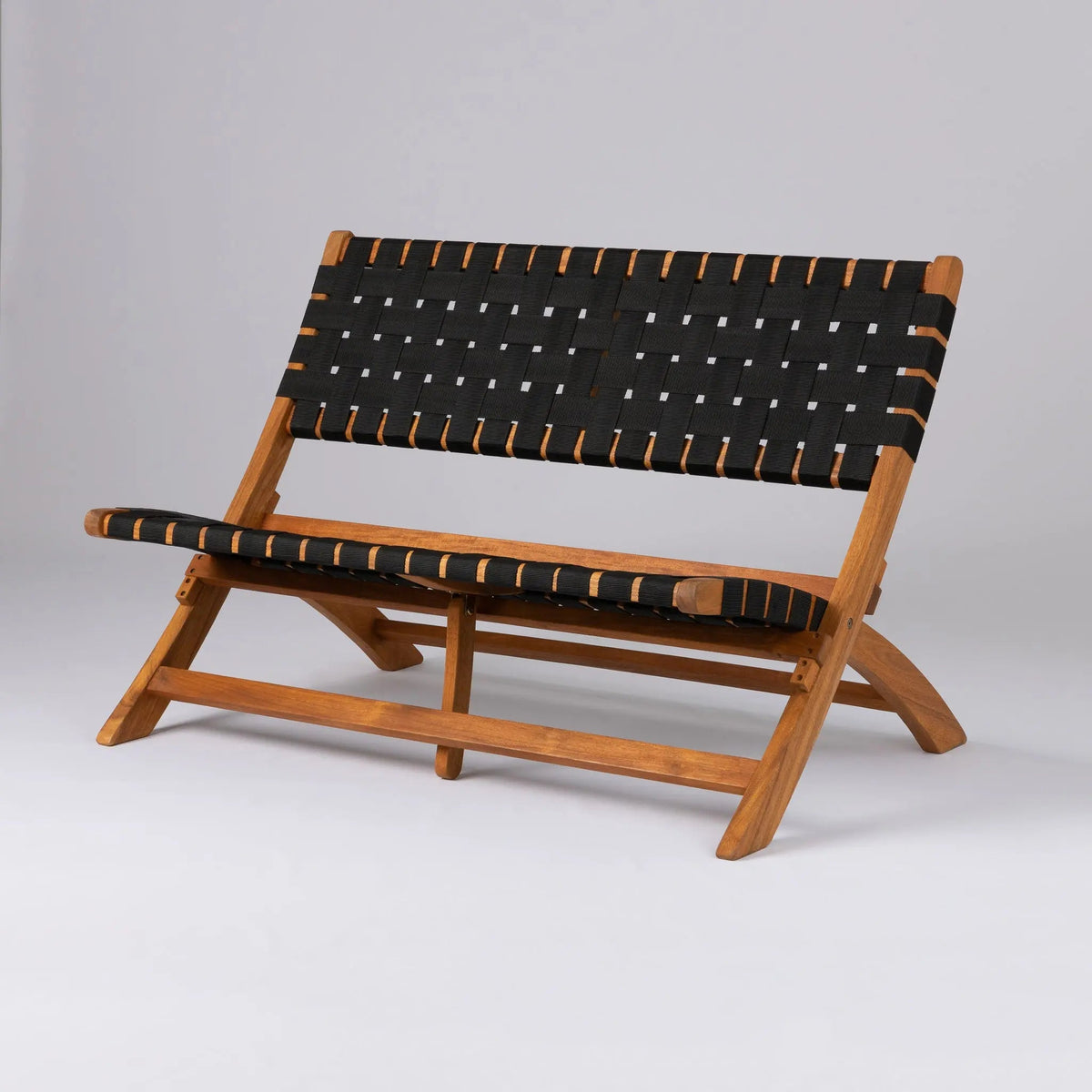Low wooden bench with angled legs and black woven fabric straps across the seat and backrest, shown against a plain light gray background.