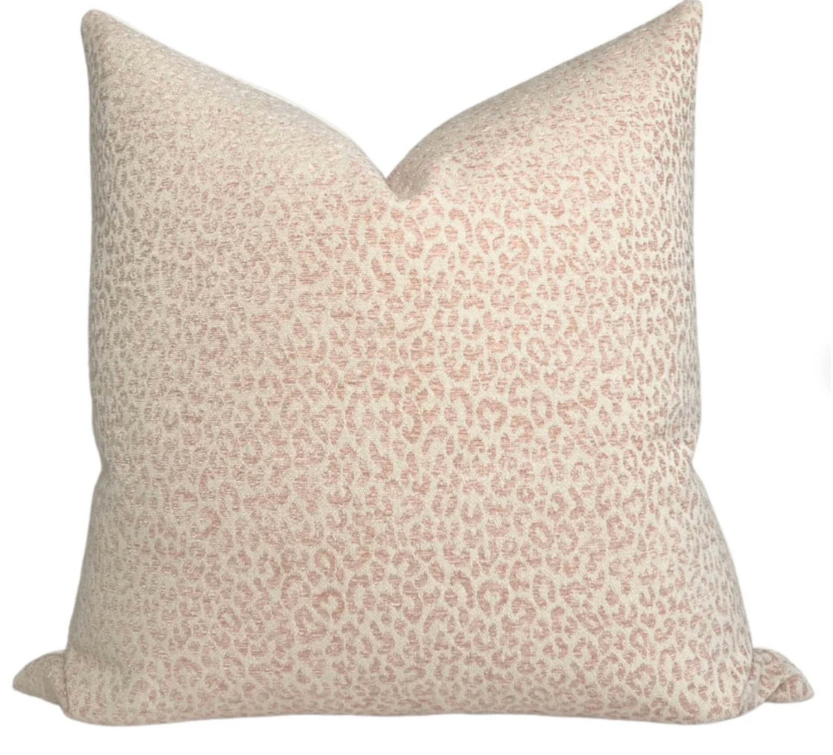 Blush pink spotted pillow cover shown on a simple couch
