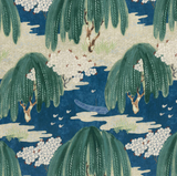 Patterned fabric featuring green willow trees with drooping leaves, white flower clusters, and a small blue boat on a deep navy background with cream accents.