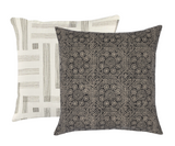 Two square pillows, one with a dense black floral dot pattern on a beige background, the other with a beige background and simple black linear geometric stripes.
