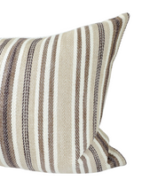 Close-up of a tan and cream pillow cover featuring vertical stripes in various widths and subtle textured fabric weave.
