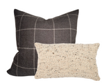Two wool pillow covers: a larger square one with dark brown and beige plaid pattern, and a smaller rectangular one with a textured beige and brown speckled weave.
