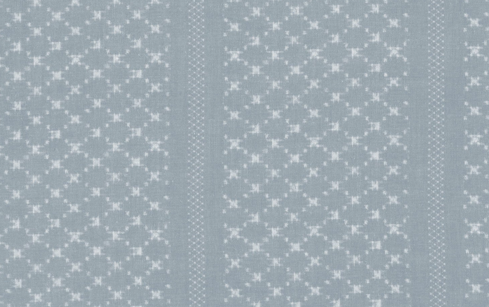 Wallpaper with repeating vertical stripes of small white floral patterns in star clusters on a soft, muted blue background.