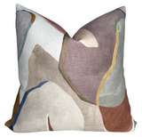 Square pillow cover with abstract shapes in muted tones of mauve, beige, blue, brown, and olive green, featuring a subtle textured fabric weave.