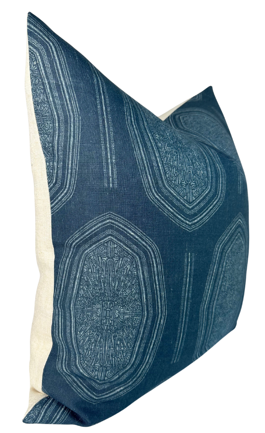 Rectangular pillow cover with deep indigo blue fabric front featuring irregular geometric medallion patterns in lighter blue tones and natural beige fabric back.