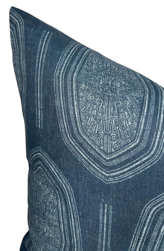 Indigo blue pillow cover with intricate white geometric and linear patterns creating a textured, symmetrical design on woven fabric.