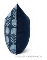 Square pillow with one side featuring a blue and white floral block print pattern and the other side solid indigo blue fabric, shown at an angle on white background.