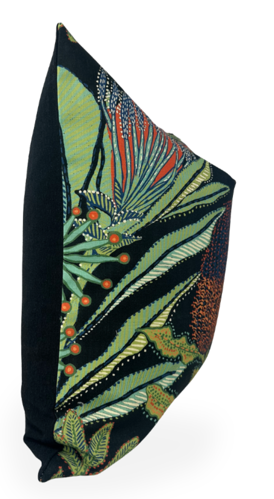 Rectangular pillow with black velvet back and front featuring colorful botanical design with green leaves, orange berries, and intricate patterns against a dark background.