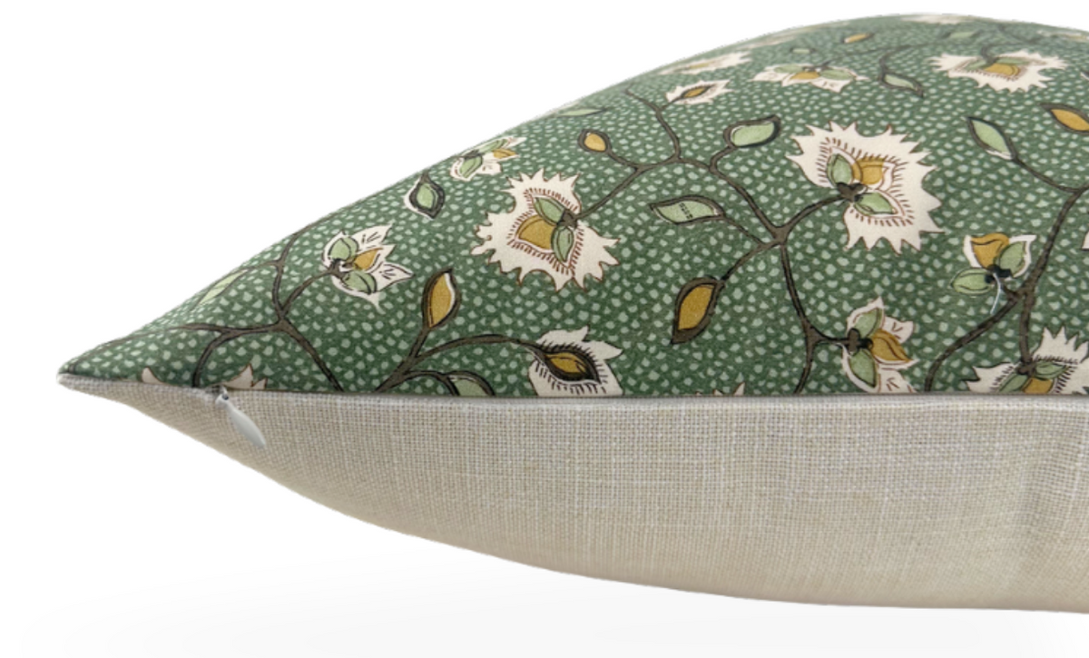 Rectangular pillow with a green floral patterned fabric on top featuring white flowers and yellow accents, and a plain beige fabric on the underside.