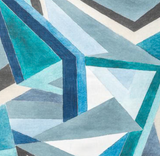 Abstract geometric pattern with overlapping triangles in shades of navy blue, teal, gray, and white on a fabric surface.