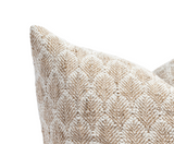 Close-up of a pillow corner with textured beige and white floral pattern woven in a natural fabric.
