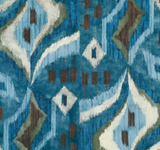 Patterned fabric with abstract geometric shapes in shades of mineral blue, olive green, brown, and white resembling an ikat textile design.