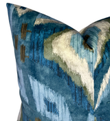 Velvet pillow cover with abstract blue, green, beige, and brown brushstroke patterns on a textured mineral blue background