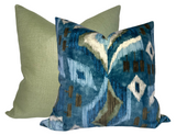 Two square pillows, one with a solid light green fabric and one with a blue velvet cover featuring abstract white, brown, and green patterns.