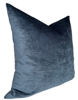Square sapphire blue velvet pillow cover with a soft sheen and subtle texture, shown angled to highlight its plush fabric.